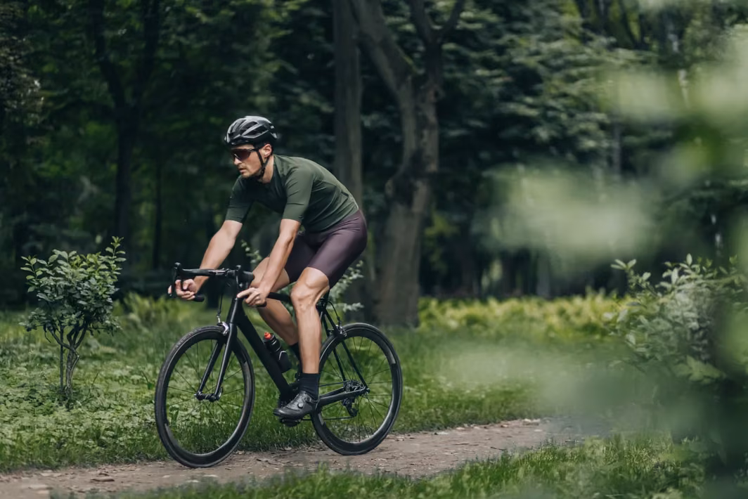Man i toppform som cyklar på en skogsstig